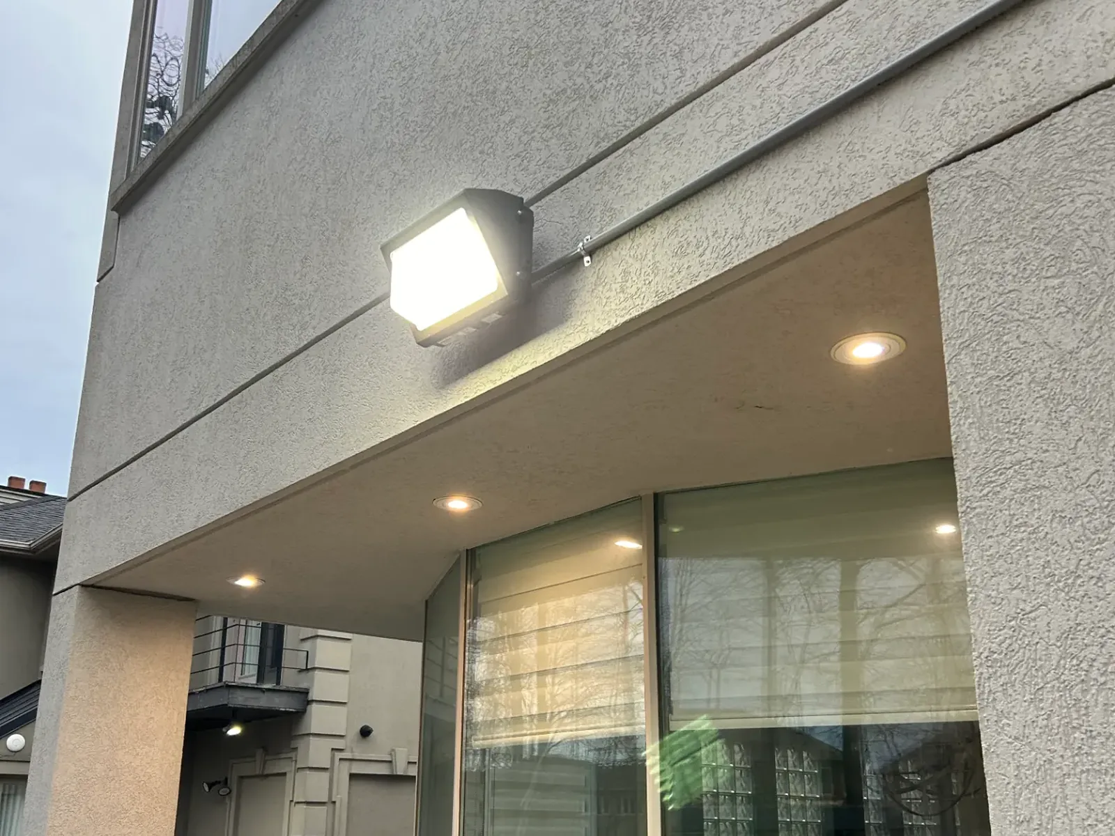 New exterior wall pack floodlight installed above a patio door at a GTA rental property