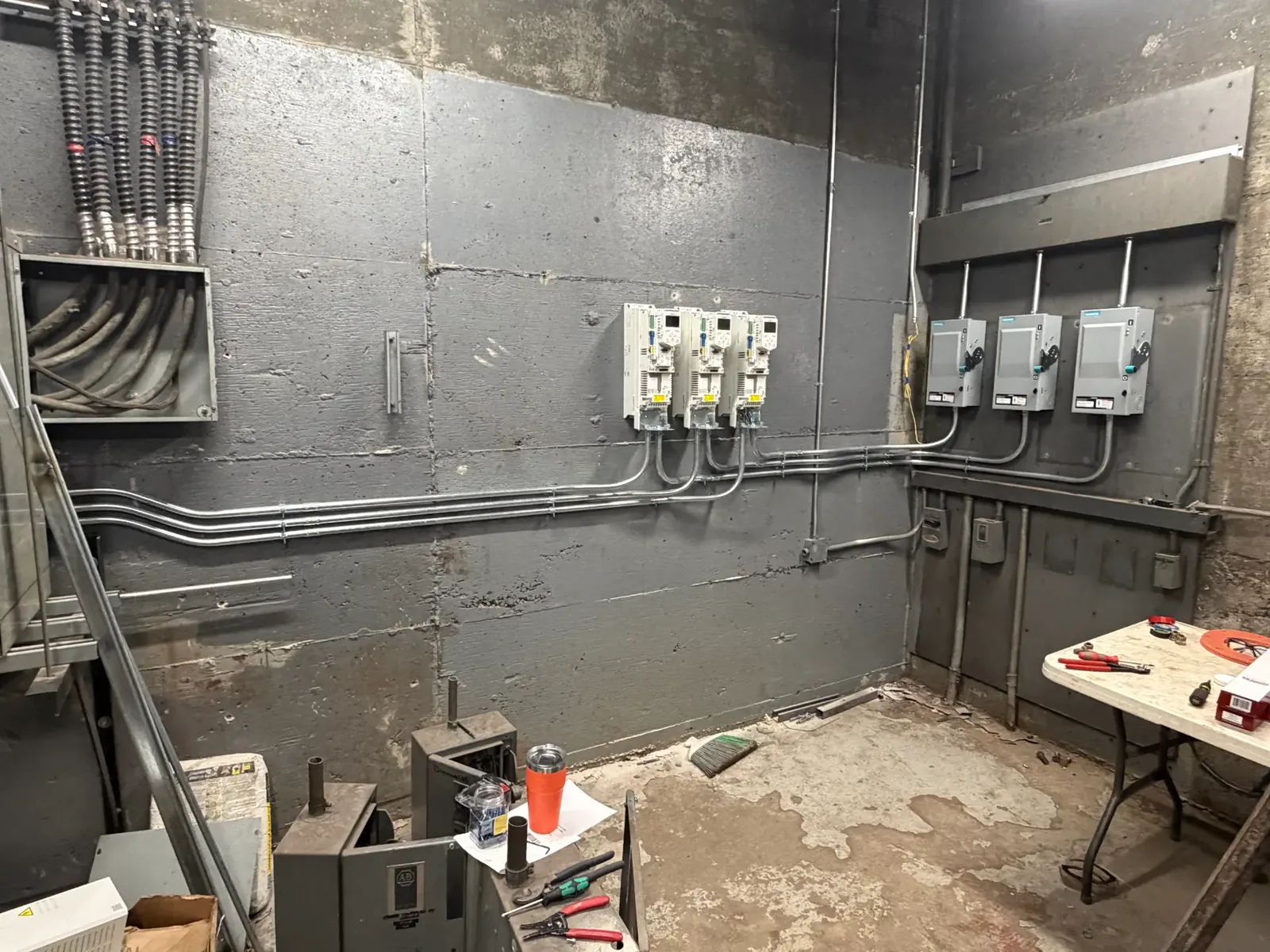 New drives and disconnects installed with conduit runs in a commercial mechanical room