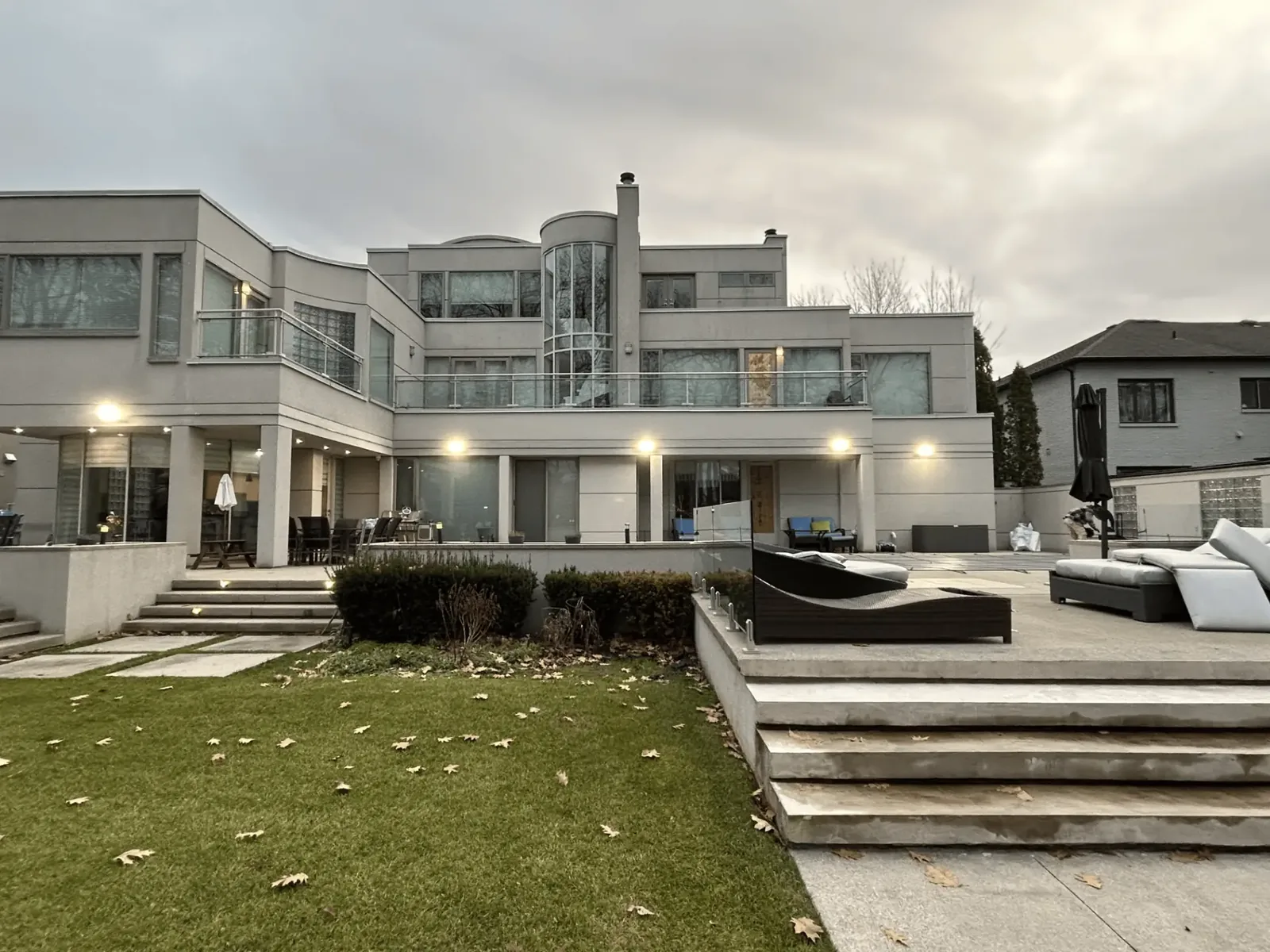 Exterior lighting illuminating the rear of the property at dusk
