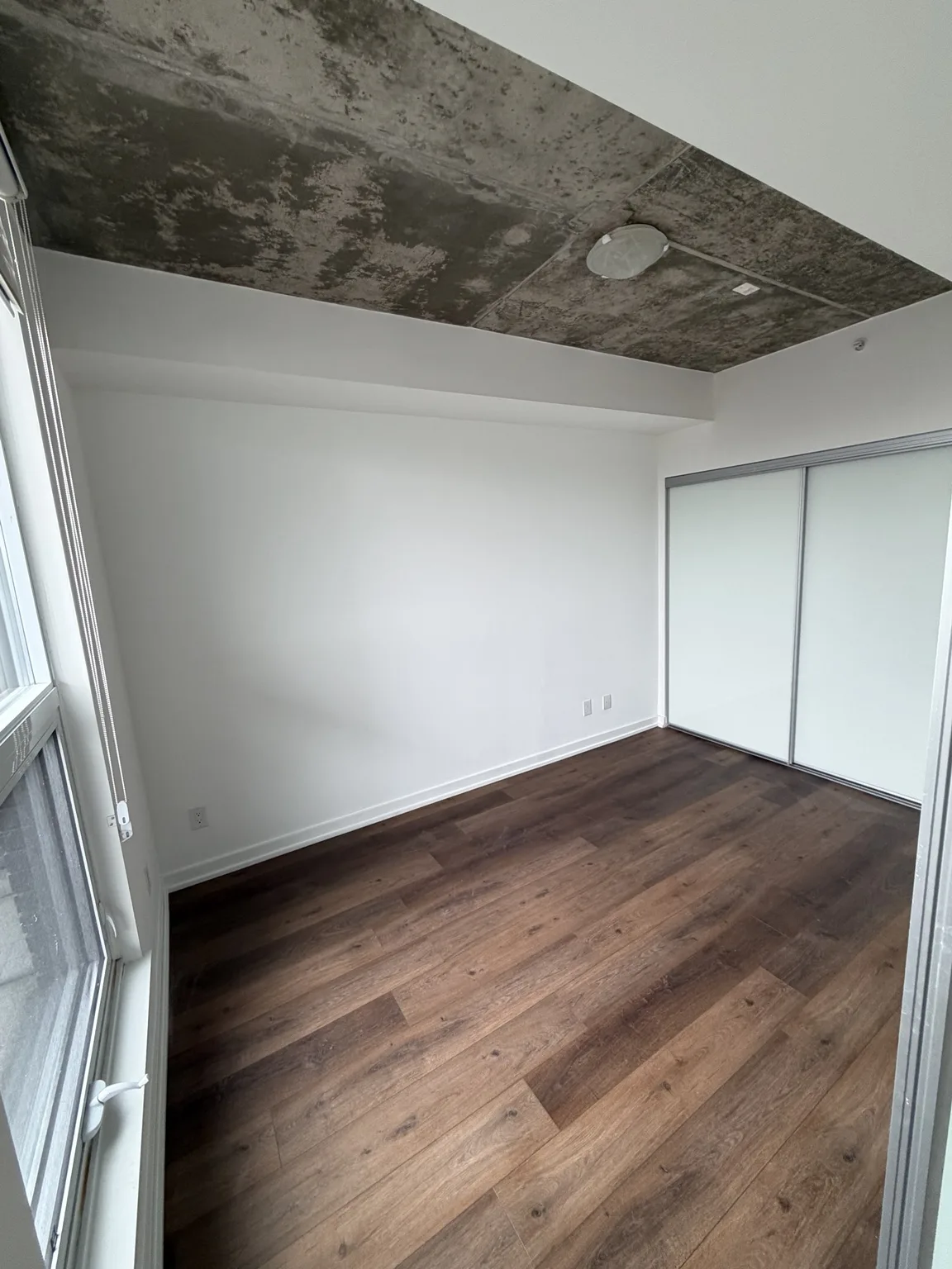 Repainted condo bedroom with sliding closet doors and refinished trim